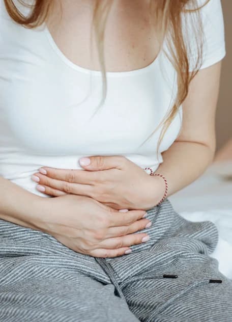 A woman holding her lower abdomen in pain